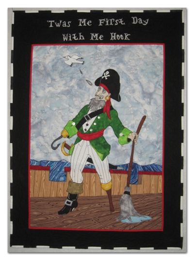 The inspiration drawing was by my husband, Michael Ellis. The materials are commercial cottons. The wording is done with thread painting and the pirate is raw-edge fusible appliqué.